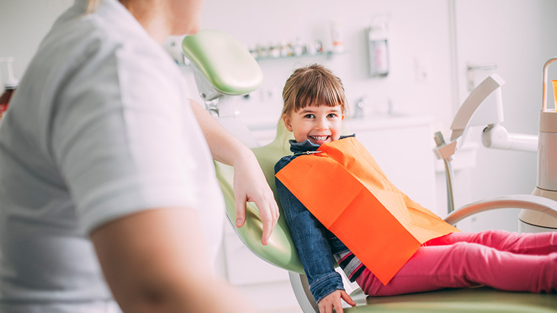 Mädchen lacht mit gesunden Zähnen beim Kinderzahnarzt in Magdeburg.